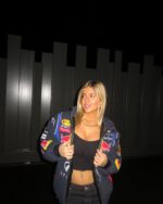 Side profile of water-resistant red bull F1 jacket women by Trycity