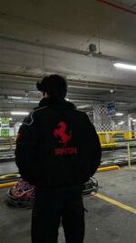Back design of sustainable black Ferrari jacket with logos